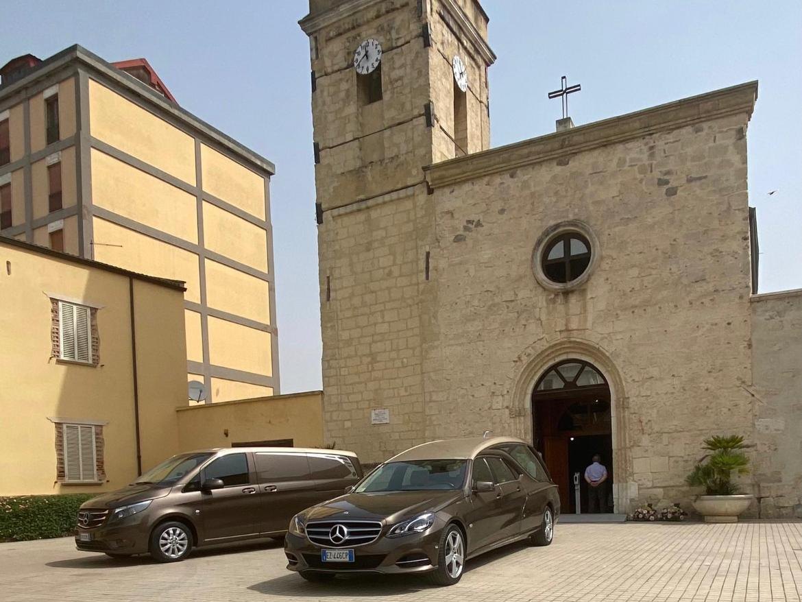 Carro funebre e vettura di servizio davanti alla chiesa prima di una cerimonia