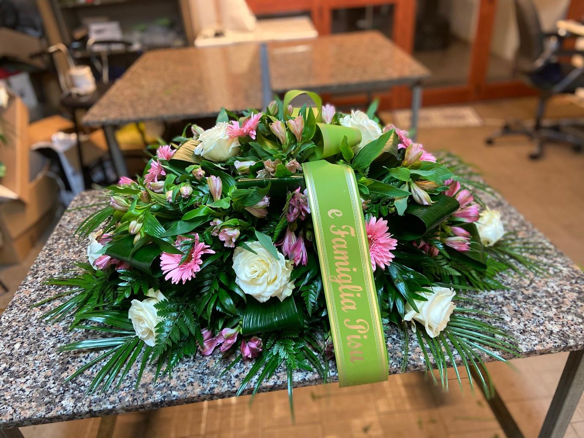 Copribara di rose e gerbere composto nel laboratorio floreale dell'agenzia