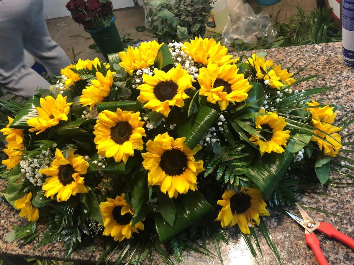 Composizione funebre con girasoli in preparazione nel laboratorio